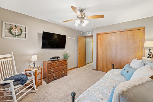 bedroom featuring light carpet, ceiling fan, and a closet