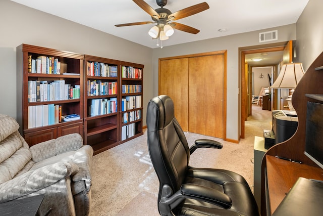 carpeted office space with ceiling fan