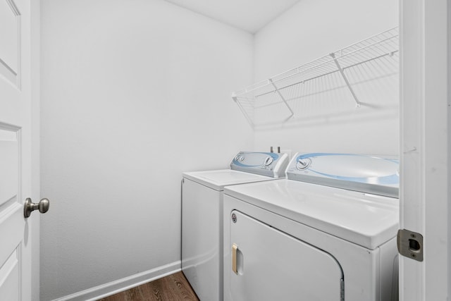 laundry room with separate washer and dryer and dark hardwood / wood-style flooring