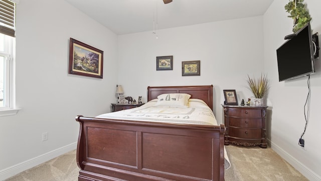 bedroom featuring light carpet, baseboards, and a ceiling fan