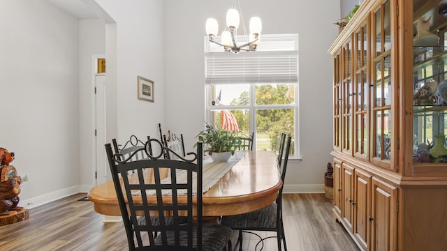 dining space with an inviting chandelier, wood finished floors, and baseboards