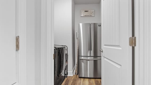 room details with wood finished floors, freestanding refrigerator, and baseboards