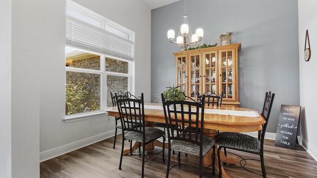 dining area featuring an inviting chandelier, wood finished floors, and baseboards