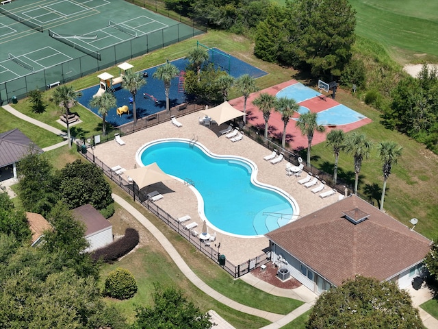 community pool with a patio area and fence