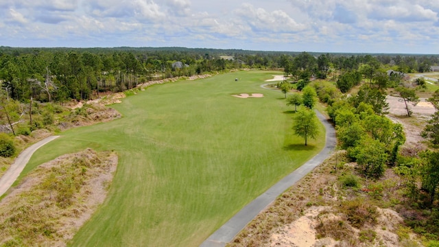 bird's eye view featuring view of golf course and a forest view