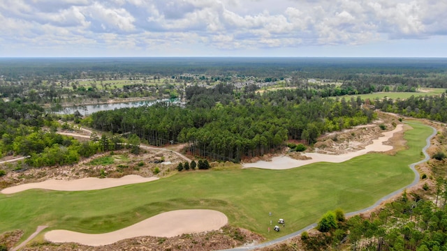 drone / aerial view featuring a forest view, golf course view, and a water view