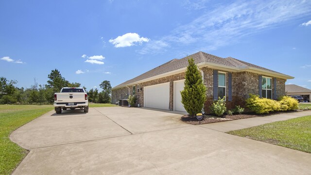 view of side of home with a garage, concrete driveway, brick siding, and a yard