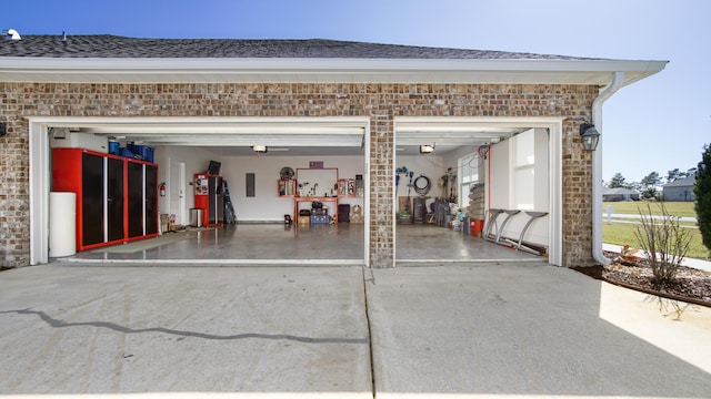 garage with concrete driveway and electric panel