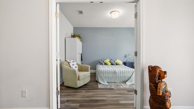 interior space with baseboards, visible vents, and wood finished floors