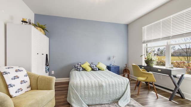 bedroom featuring wood finished floors and baseboards