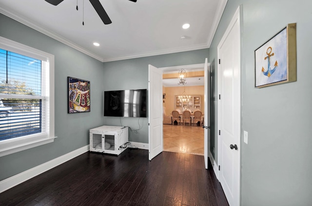 interior space with ornamental molding, ceiling fan with notable chandelier, and dark hardwood / wood-style floors