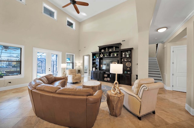 living room featuring light tile patterned floors, ceiling fan, a high ceiling, french doors, and crown molding