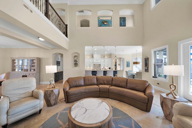 living room with a towering ceiling and light tile patterned flooring