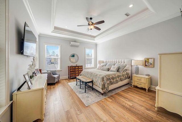 bedroom featuring an AC wall unit, wood-type flooring, ornamental molding, a raised ceiling, and ceiling fan