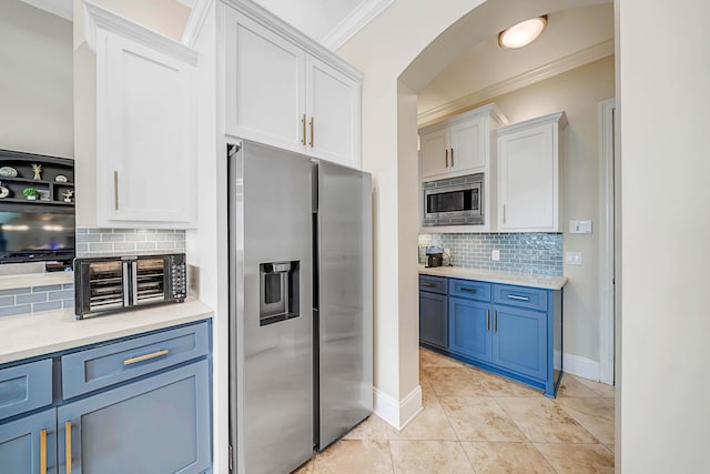 kitchen with white cabinetry, stainless steel appliances, decorative backsplash, light tile patterned flooring, and blue cabinets