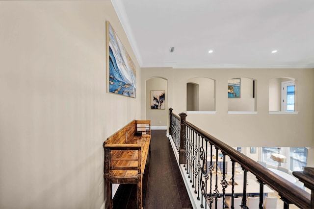 corridor with wood-type flooring and crown molding