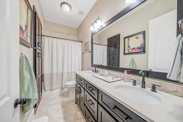 bathroom featuring toilet, vanity, and a shower with shower curtain