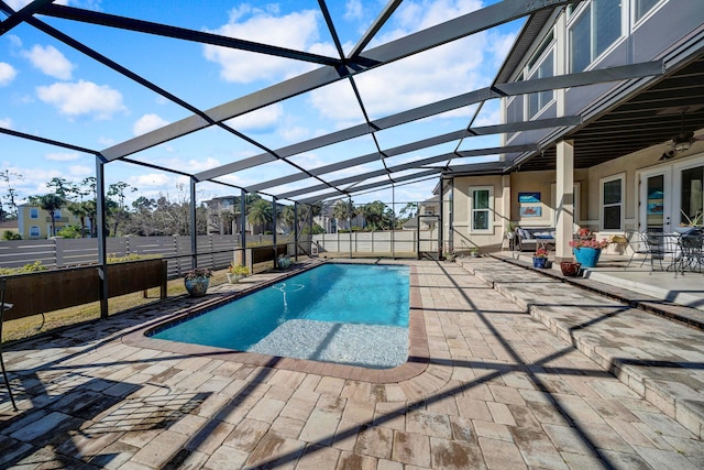 view of swimming pool with glass enclosure and a patio