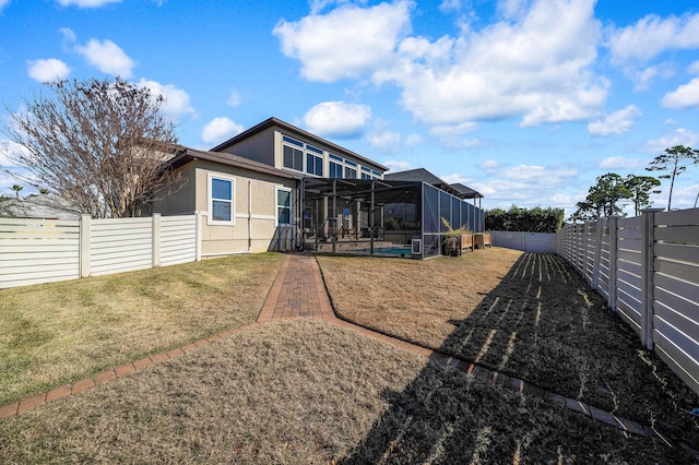 rear view of property featuring glass enclosure, a pool, and a yard