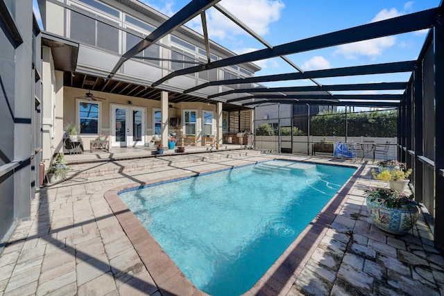 view of swimming pool featuring ceiling fan, glass enclosure, and a patio area