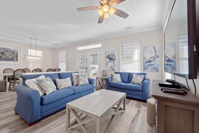 living room with ceiling fan, ornamental molding, and light hardwood / wood-style flooring