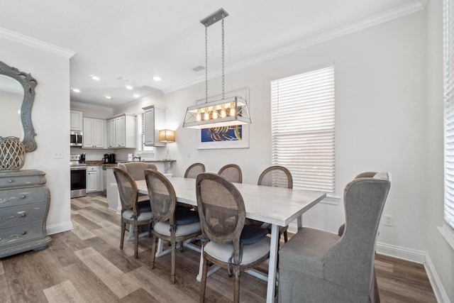 dining area featuring light wood-type flooring, ornamental molding, and plenty of natural light