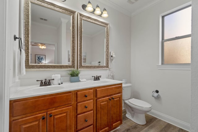 bathroom with toilet, vanity, crown molding, and hardwood / wood-style floors