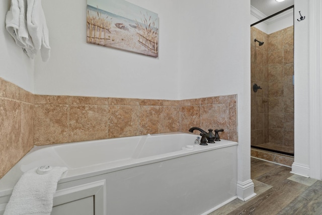 bathroom featuring wood-type flooring, ornamental molding, and separate shower and tub