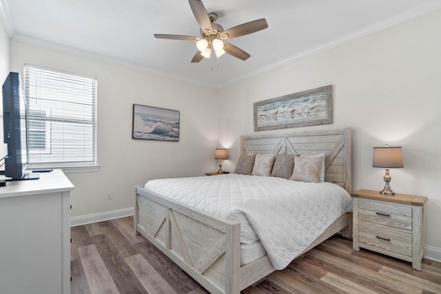 bedroom featuring ceiling fan, ornamental molding, multiple windows, and hardwood / wood-style floors