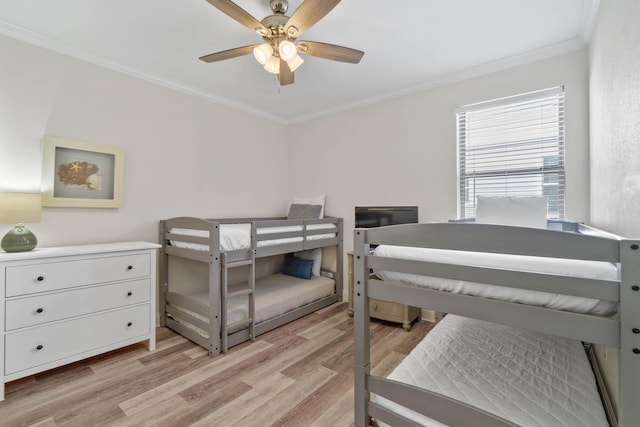 bedroom with light wood-type flooring, ceiling fan, and crown molding