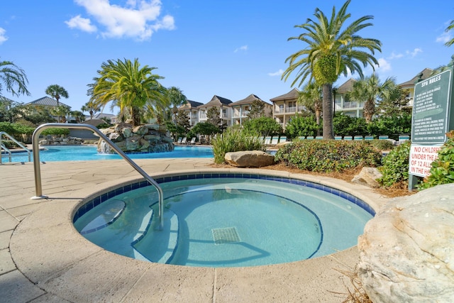 view of swimming pool with a hot tub