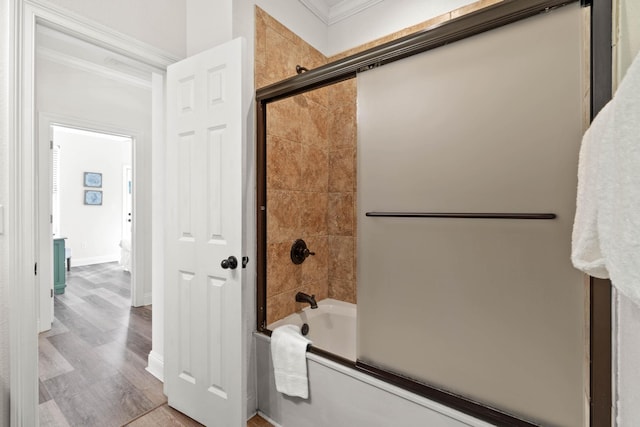 bathroom with ornamental molding, wood-type flooring, and shower / bath combination with glass door