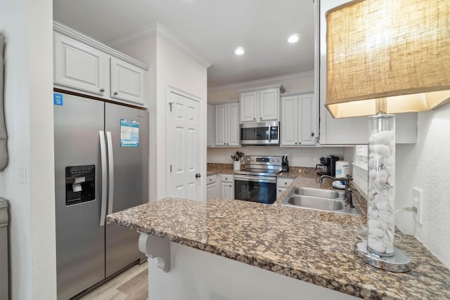 kitchen featuring sink, white cabinetry, kitchen peninsula, and stainless steel appliances