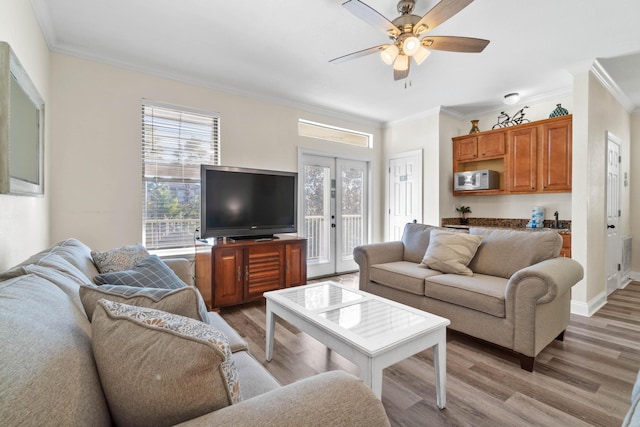 living room featuring ornamental molding, french doors, and light wood-type flooring