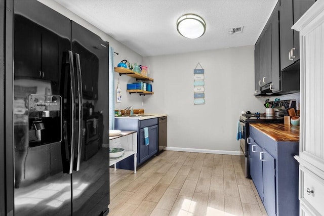 kitchen with dishwasher, wood counters, black refrigerator with ice dispenser, electric range, and light hardwood / wood-style flooring