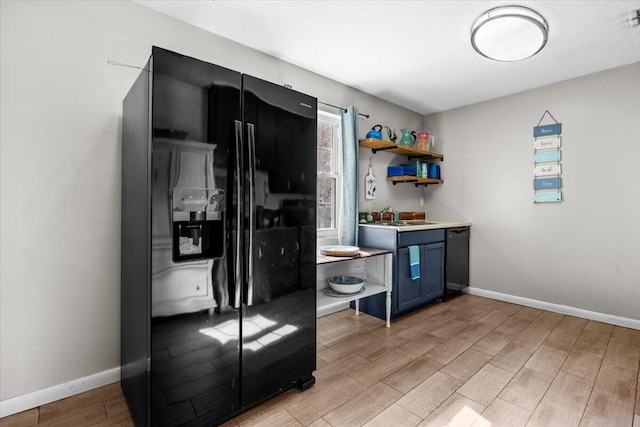 kitchen with black appliances, light wood-type flooring, sink, and blue cabinetry