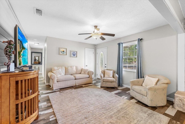 living room featuring a textured ceiling, ceiling fan, and hardwood / wood-style floors