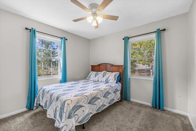 bedroom with ceiling fan, multiple windows, and carpet flooring