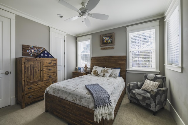 carpeted bedroom with ceiling fan, ornamental molding, and multiple windows