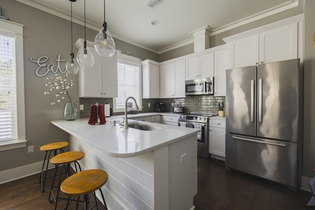 kitchen with sink, stainless steel appliances, kitchen peninsula, and white cabinets