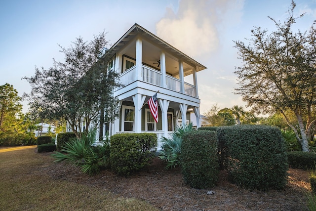 view of front of property featuring a balcony and ceiling fan