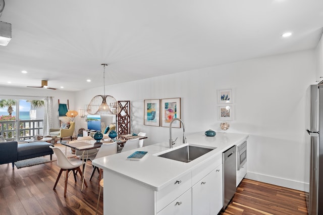 kitchen featuring pendant lighting, sink, dark wood-type flooring, white cabinets, and kitchen peninsula