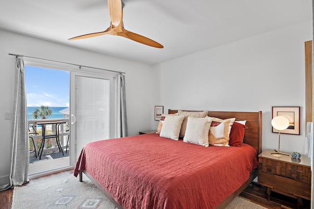 bedroom with ceiling fan, access to outside, wood-type flooring, and a water view