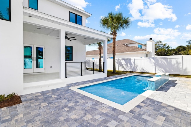 view of pool with ceiling fan, french doors, pool water feature, and a patio