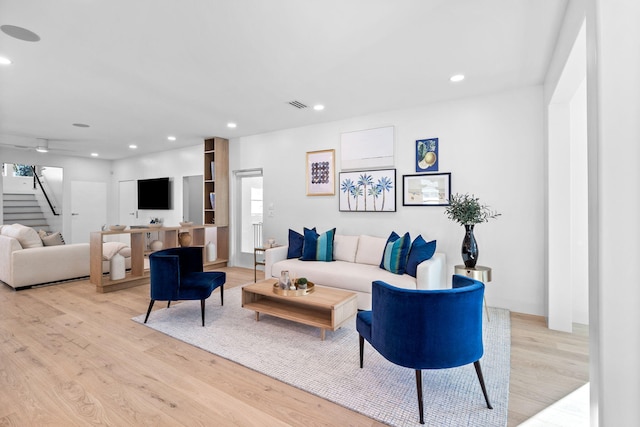 living room featuring ceiling fan and light hardwood / wood-style flooring