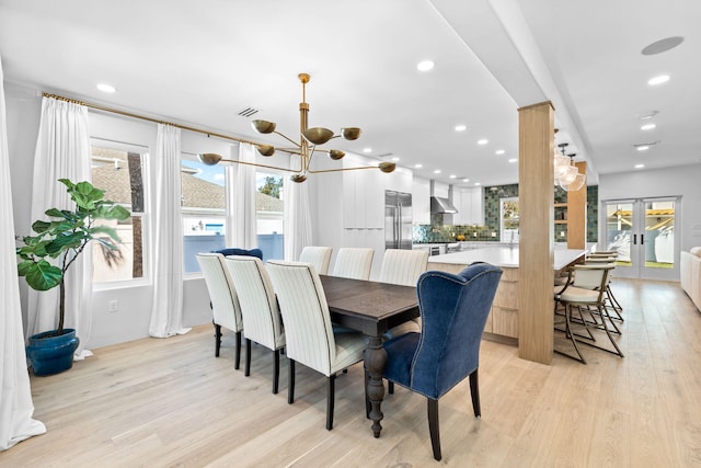 dining area featuring light wood-type flooring, french doors, and plenty of natural light