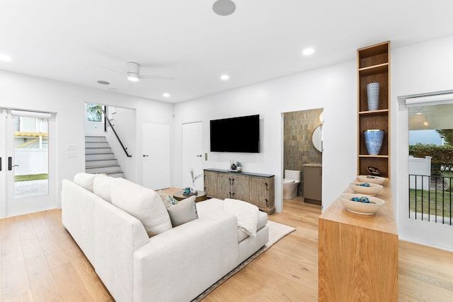 living room featuring light hardwood / wood-style floors, ceiling fan, and french doors