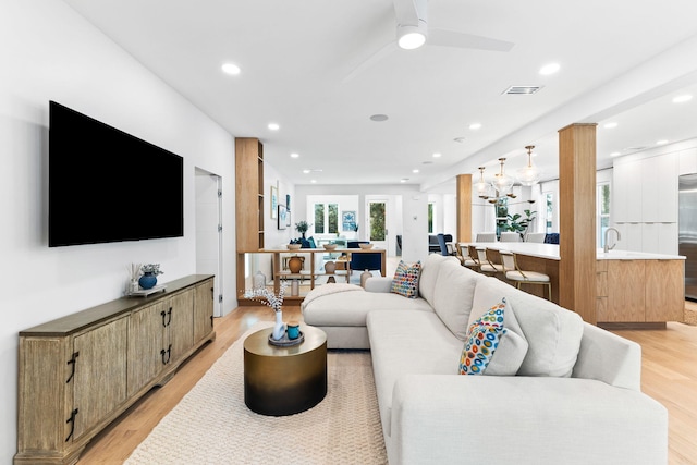 living room with ceiling fan, light hardwood / wood-style flooring, and sink