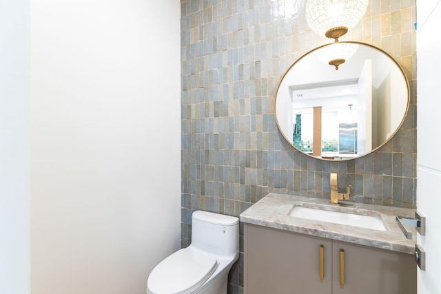 bathroom with decorative backsplash, tile walls, toilet, and vanity