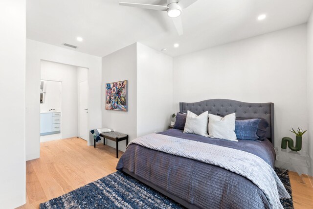 bedroom with ceiling fan, hardwood / wood-style flooring, and ensuite bath